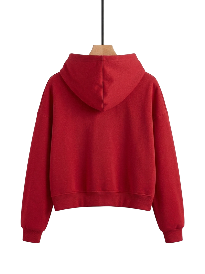 A red cropped hoodie shown from the back, hanging on a wooden hanger against a plain white background.